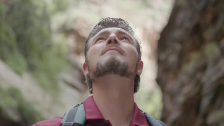 A white male stands outdoors and looks above himself