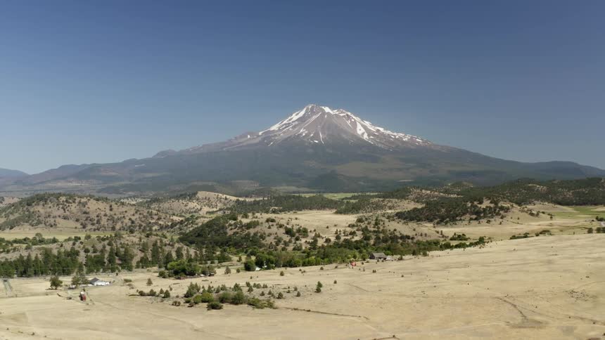 Snow capped mountain borders hills and desert