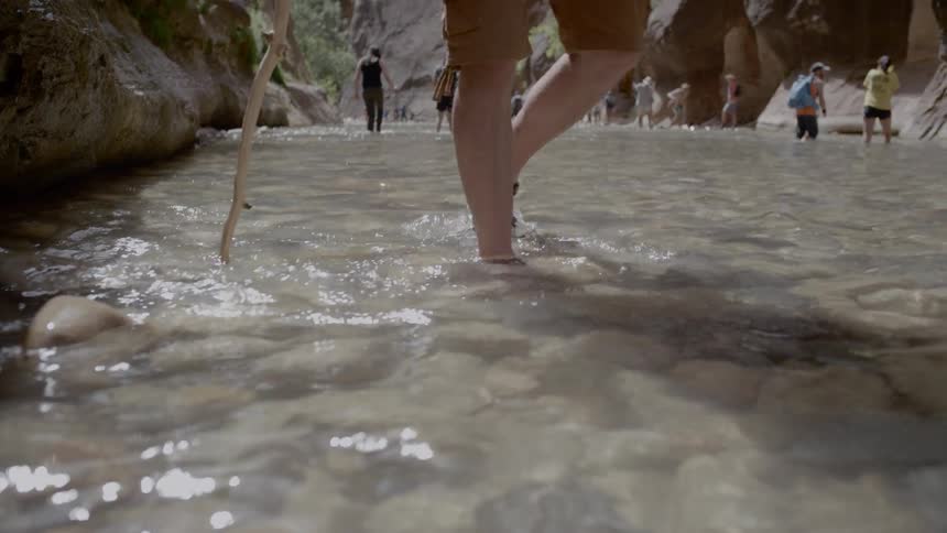 People hike in the shallow spring in the canyon