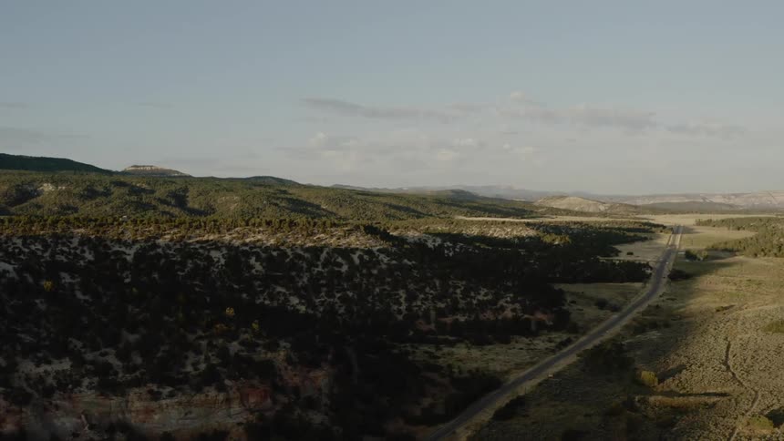 A long road runs through a mountain valley