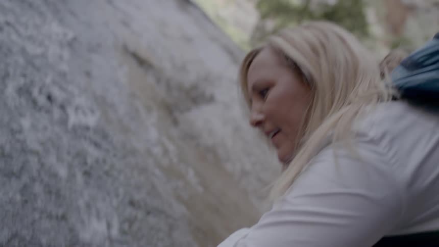 A woman lets the shallow river water flow over her hand