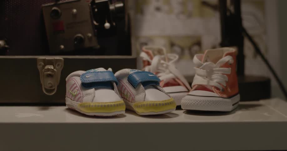 Two pairs of baby shoes on a shelf
