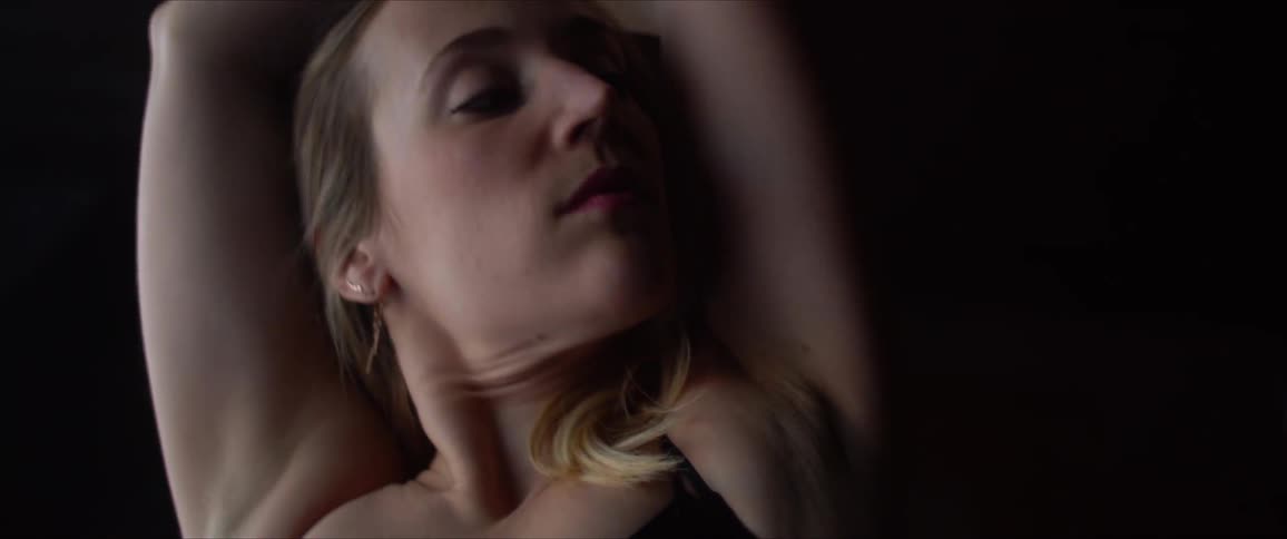 A woman stretches side to side with her arms over her head