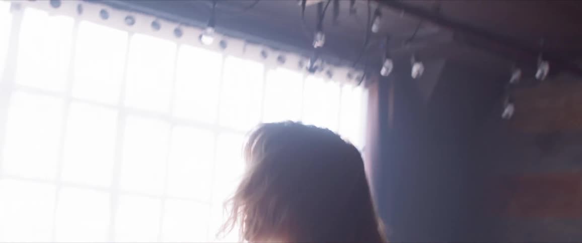 A young woman dances in a large studio