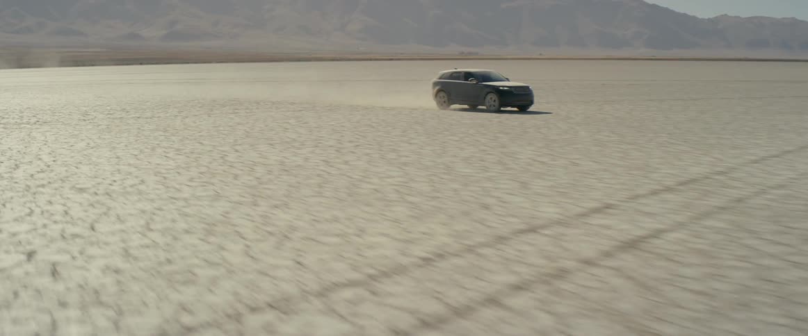 A black range rover sport driving across the salt flats
