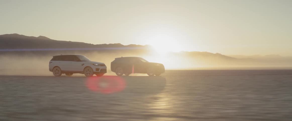 Two cars racing in the desert during sunrise