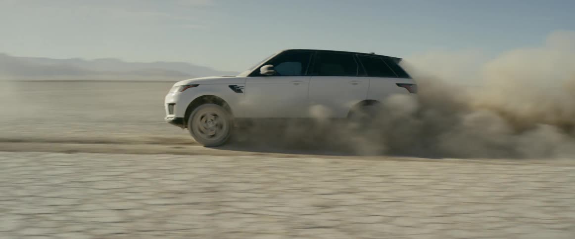 A white range rover sport driving across the salt flats