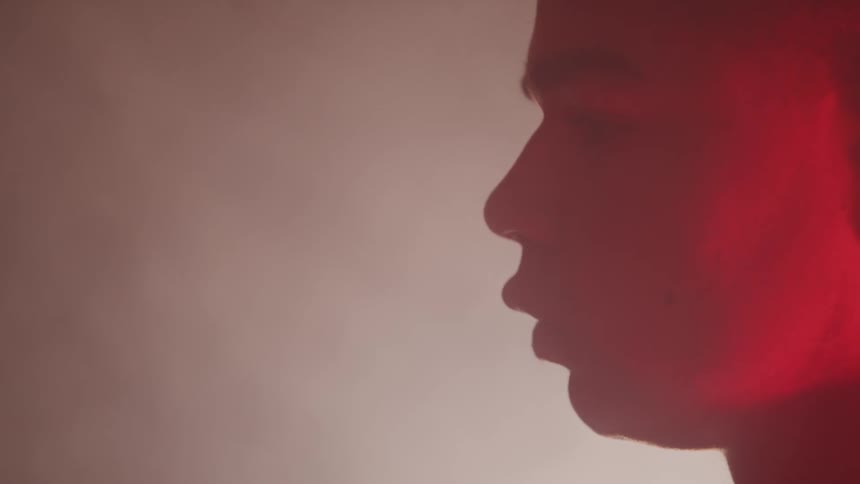 A man is looking forward in a smoke filled room