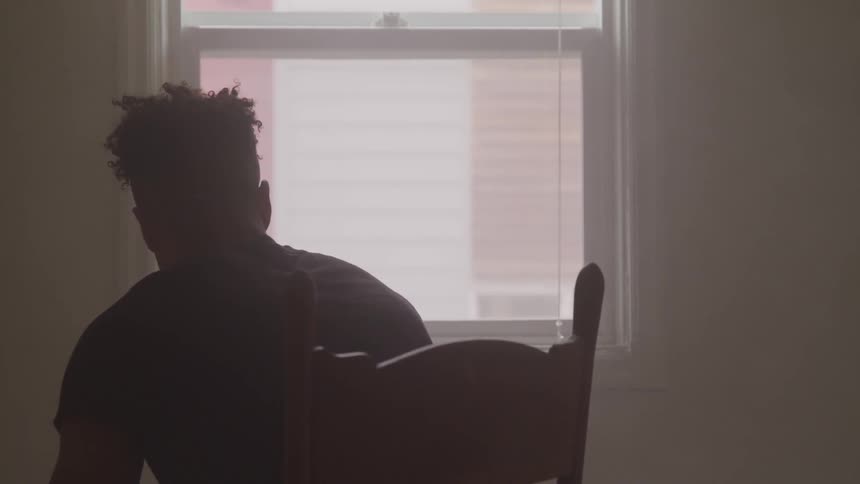 A man sitting in a chair looking out the window