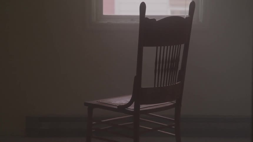 A wooden chair sits in an empty room