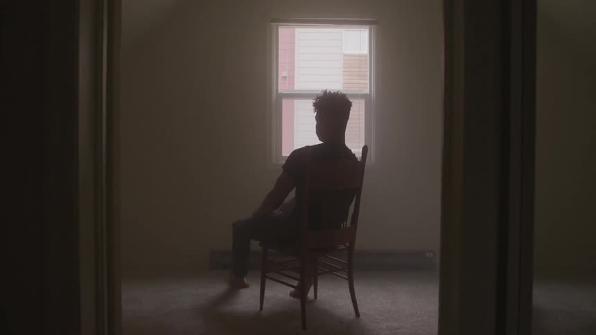 A man sitting in a chair in an empty room