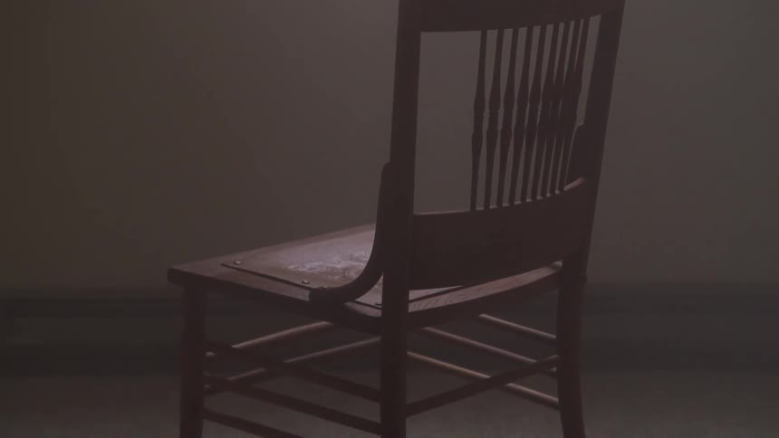 Brown chair sits in an empty room near a window