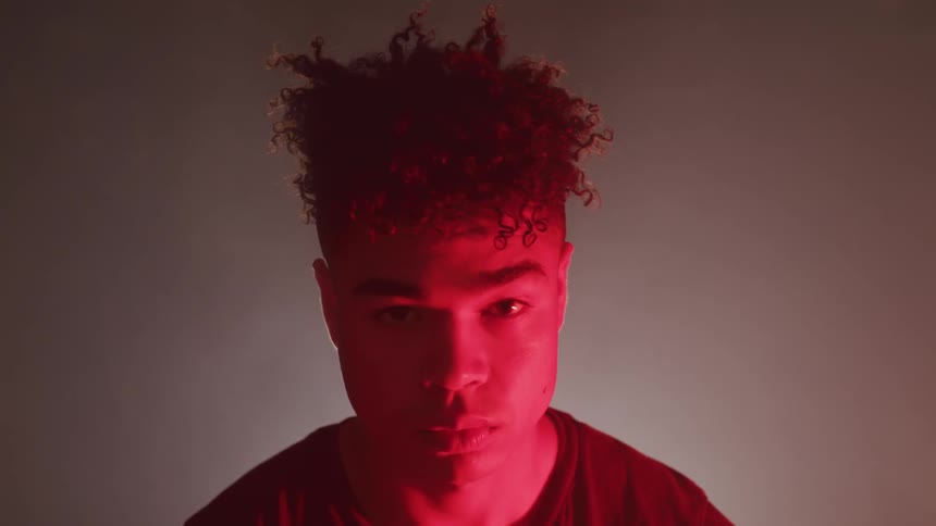 A man staring with red light on his face