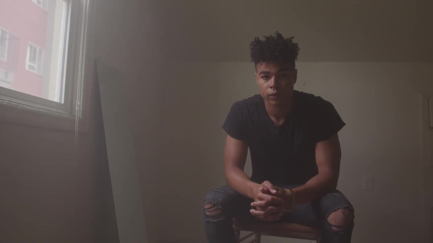 A man sitting in an empty room in a mirror