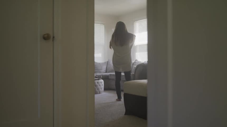 A woman is talking on the phone in the living room