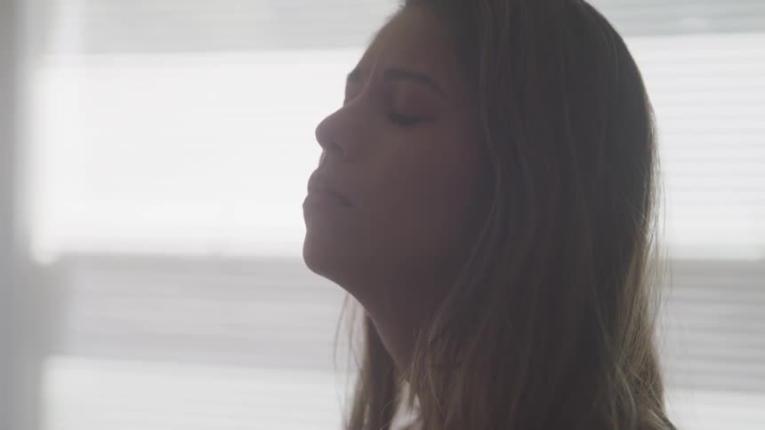 A woman inside looking up then closing her eyes