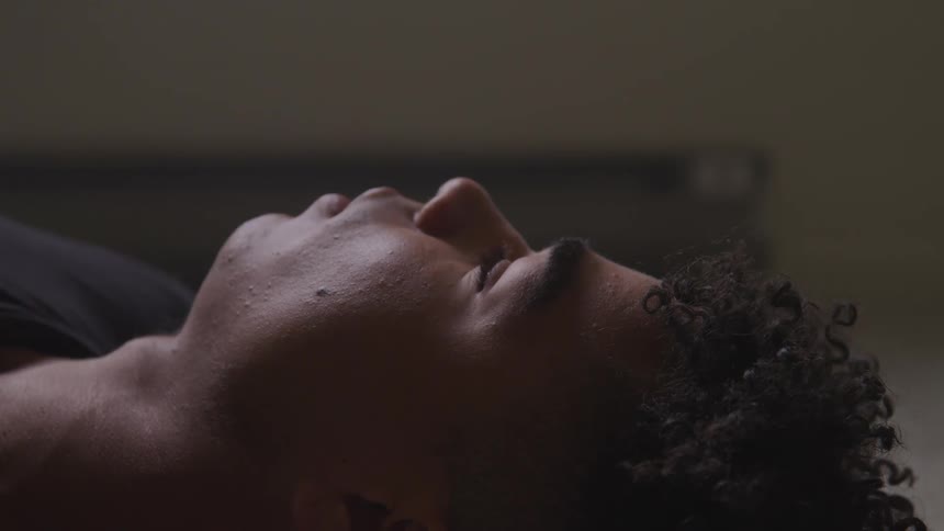 A black teenager lies on his back looking up