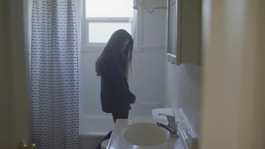 A teen girl standing at the bathroom