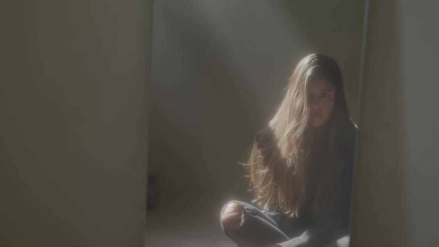 A woman sits cross legged on the floor
