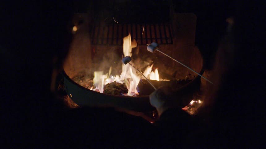 People roast marshmallows over a fire