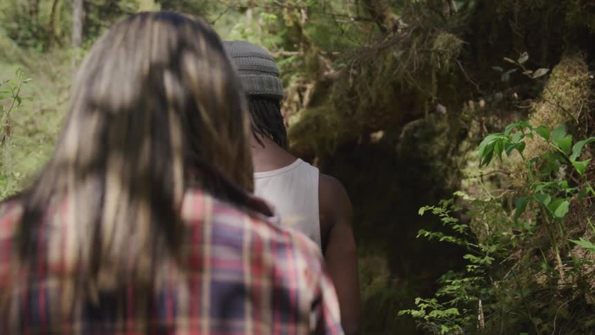 A man and a woman hike in the woods