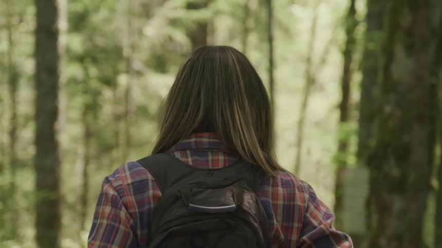 A woman backpacks through the forest