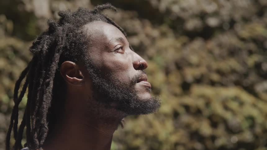 Black man looks towards the sky as he stands outdoors