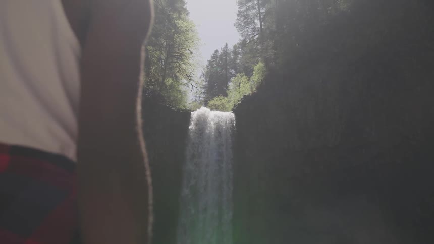 A person stares towards a large waterfall