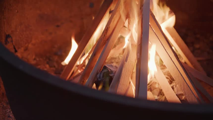 The campfire burns at night