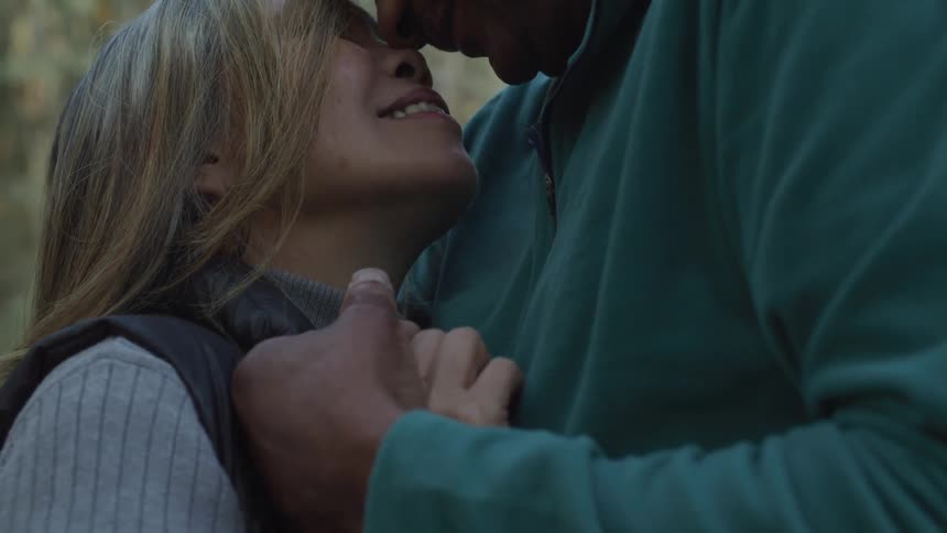 A couple slow dance and hold each other close smiling face to face