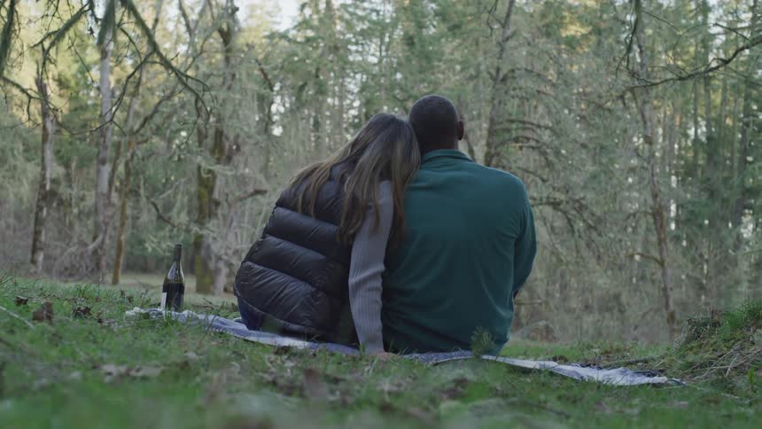 A man and woman picnicking in a park