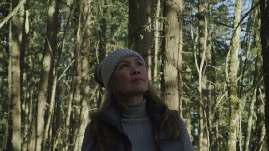 A woman with hat walking in the forest