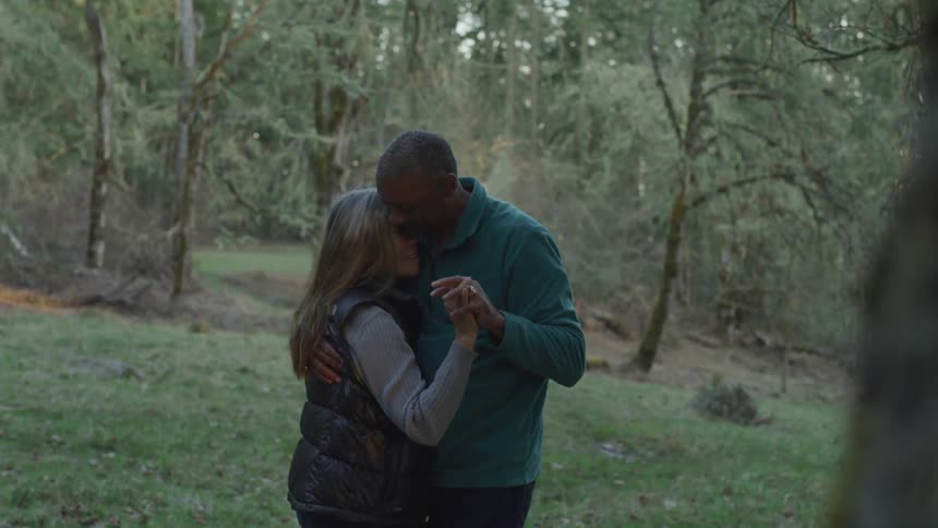 A man and woman dance together outside