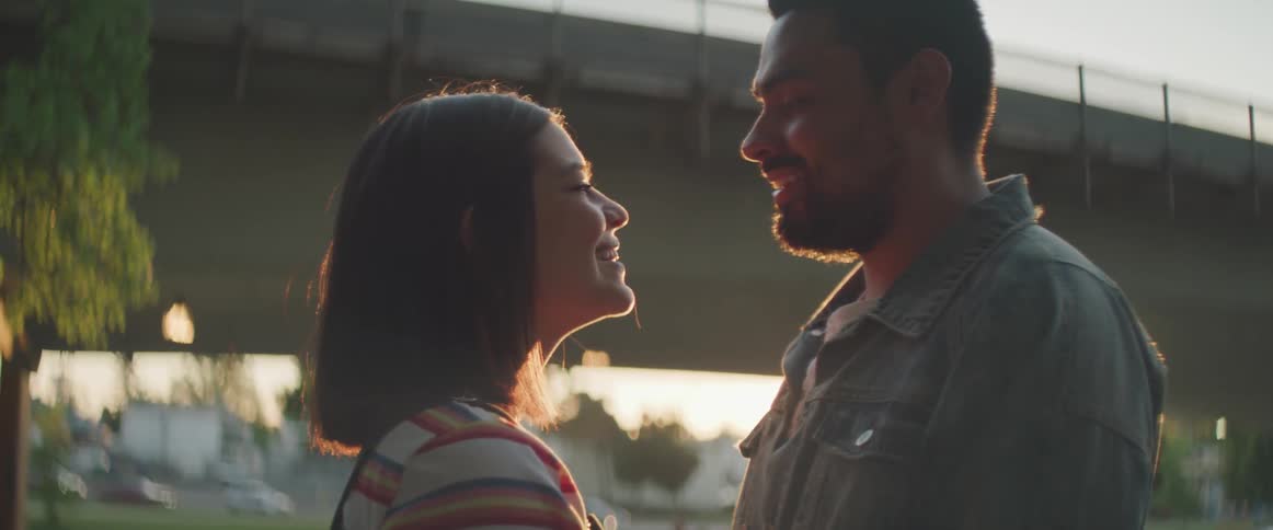 A man and woman stand together by the bridge