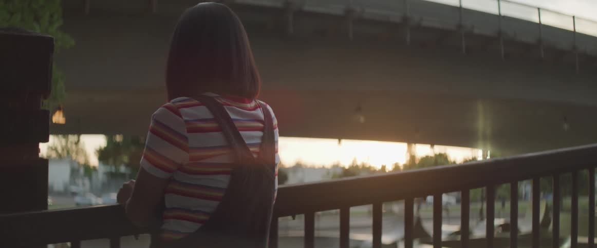 A woman standing on the edge of a bridge