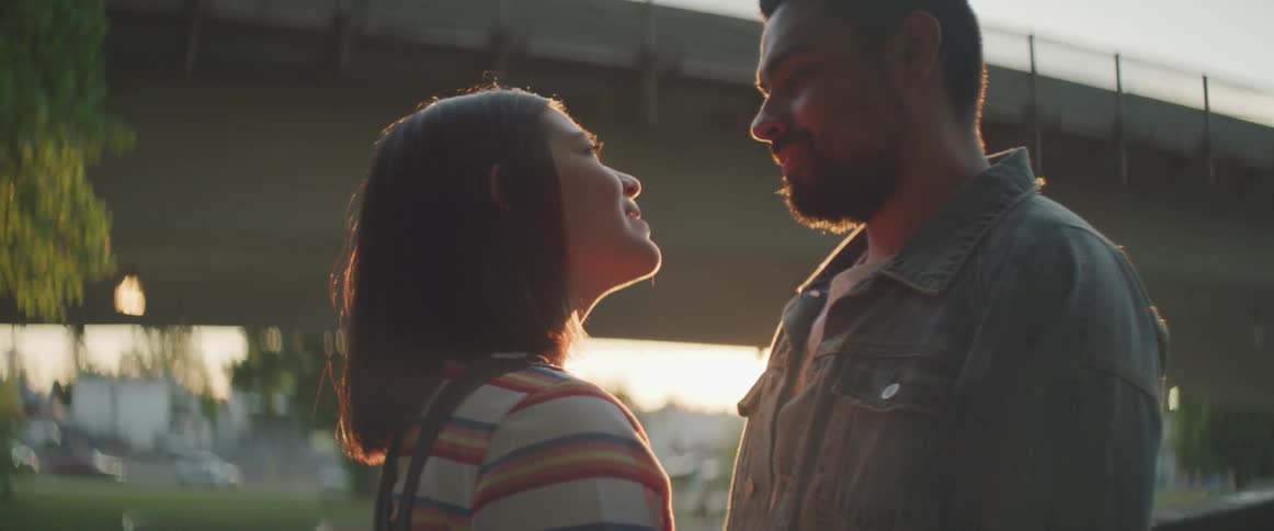 A man and woman stare into each others eyes during sunset