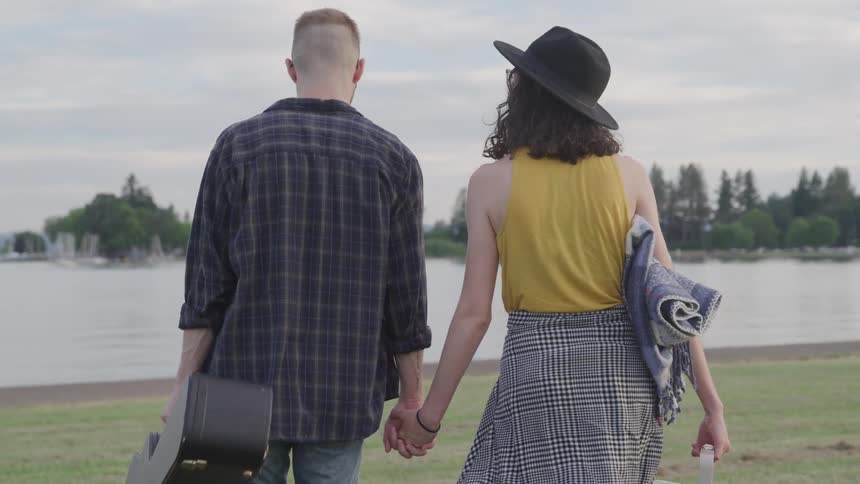 A man and woman hold hands and walk together
