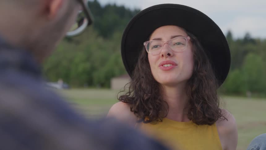 A young white woman talks and smiles at a man