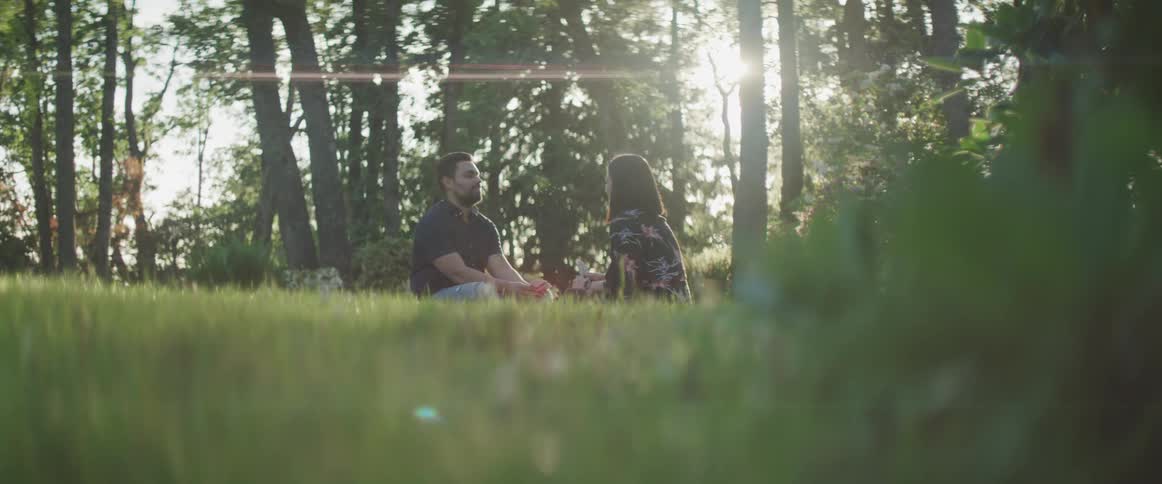 A couple is sitting in the grass