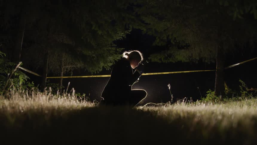 A woman takes pictures at a crime scene