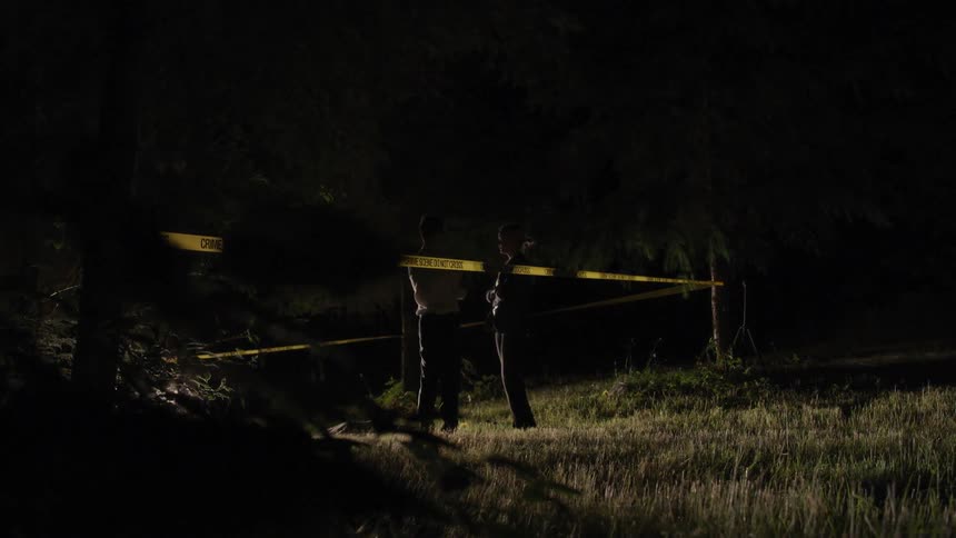Officers talk next to a police crime scene