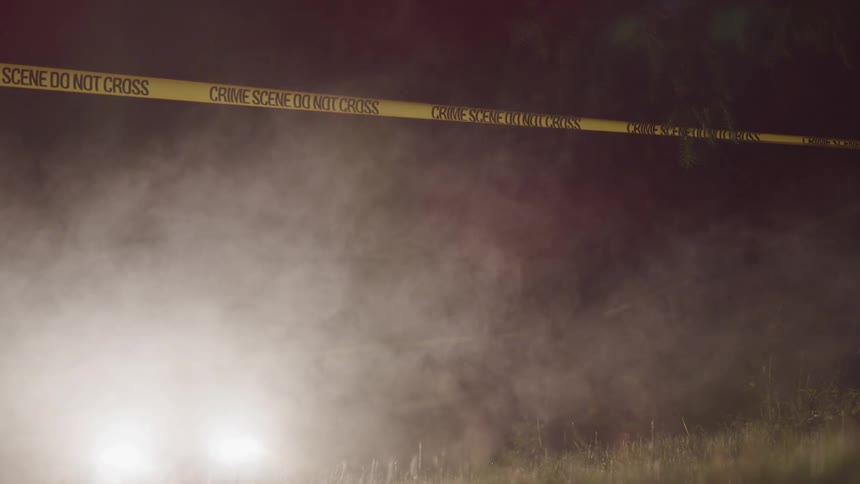 Fog hangs in the air over a field which has yellow crime scene tape across it