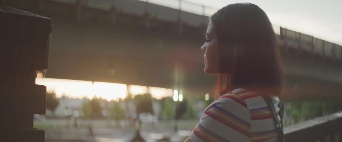 A young girl stands and looks out in to the distance