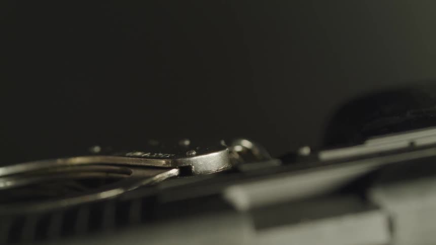 A pair of metal handcuffs shits on a table