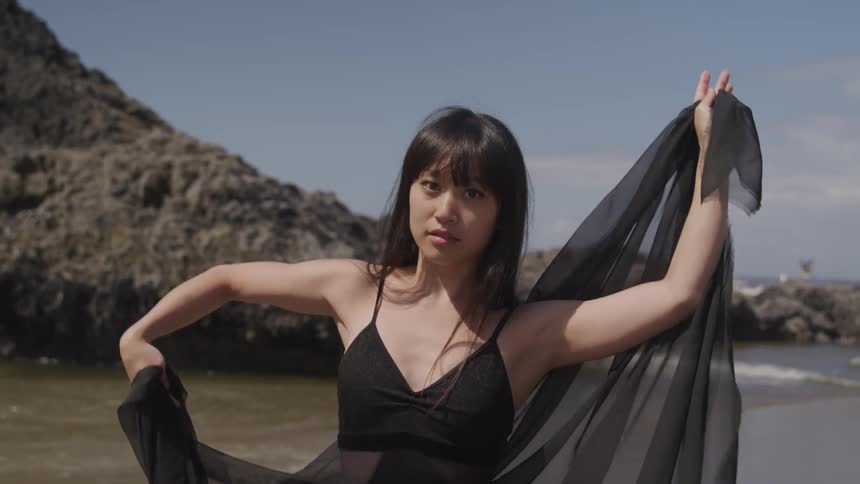 An asian woman dance on a beach