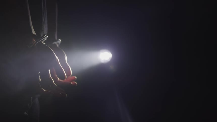 A person stands with their hands cuffed together