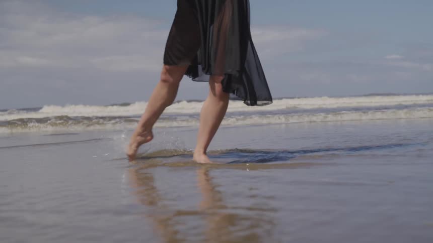 A woman dances on a beach