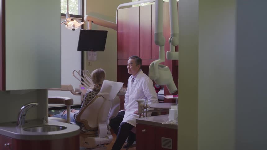 A dentist talks with a patient in the office