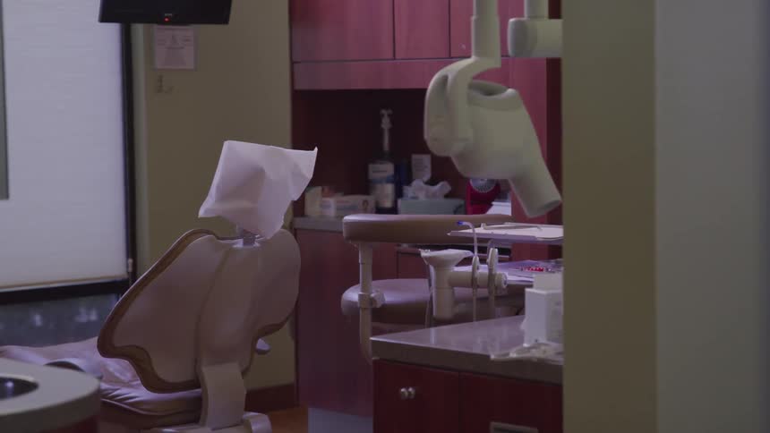 A dentists office with a chair and x ray equipment