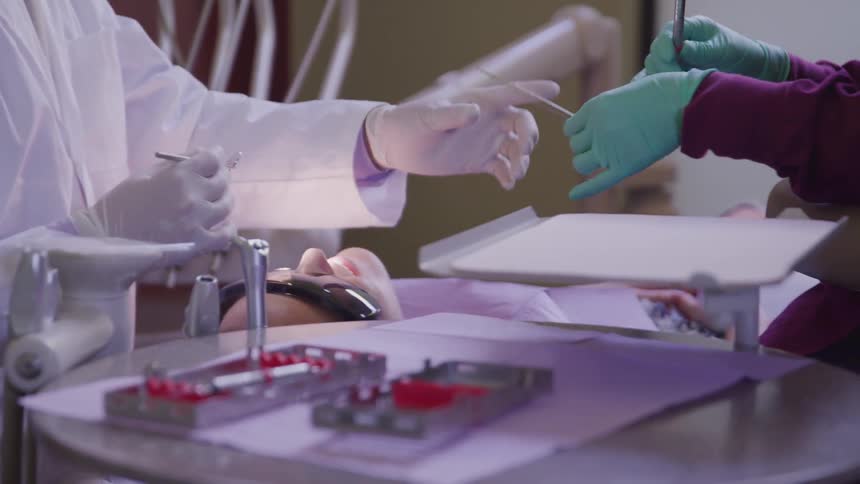 A dentist works on a patients teeth